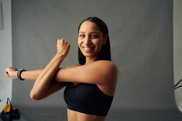 Young Biracial Woman Sports Clothing Smiling While Doing Cross Arm — стоковое фото