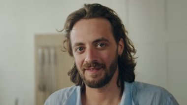 Ofiste kameraya bakarken gülen mutlu beyaz bir adamın portresi.