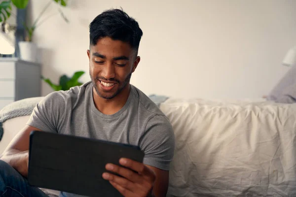 快乐的年轻人穿着休闲装 在家里的卧室里使用数码平板电脑 — 图库照片