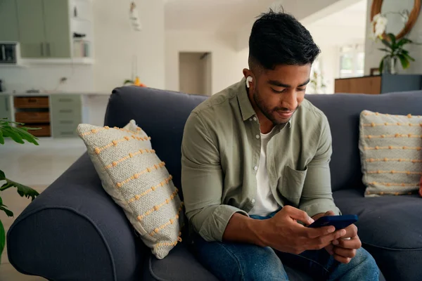 Junger Mann Lässiger Kleidung Sitzt Hause Auf Sofa Mit Handy — Stockfoto