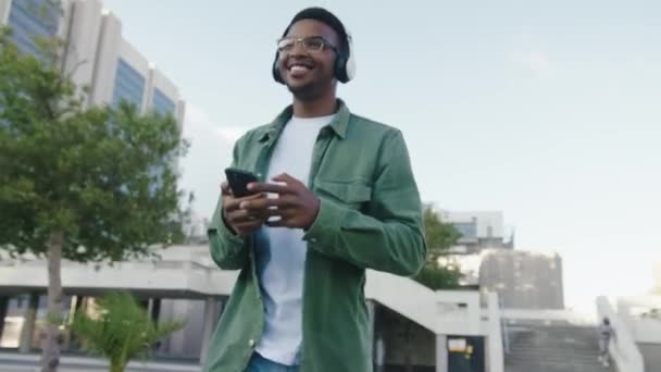 Happy Young Black Man Wearing Casual Clothing Wireless Headphones Walking — Stock Video