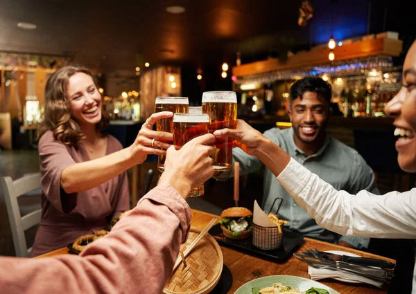 快乐的年轻多种族的朋友们穿着休闲装在餐馆里和啤酒一起举杯庆祝 — 图库照片