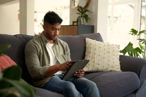 Junger Mann Lässiger Kleidung Sitzt Hause Mit Digitalem Tablet Auf — Stockfoto