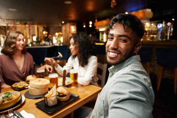 幸せな若い多人種の友人のグループは カジュアルな服を着てレストランで夕食を食べる — ストック写真