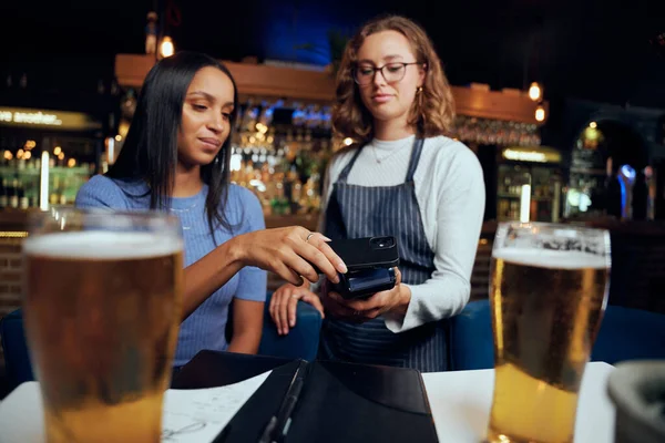 Młoda Kobieta Luźnej Odzieży Płaci Drinki Bezprzewodową Technologią Kelnerki — Zdjęcie stockowe