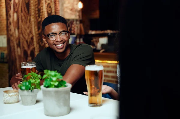 幸せな若い多人種の友人がカジュアルな服を着て笑顔と飲み物でジェスチャーレストラン — ストック写真