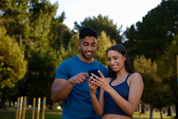 Glada Unga Multiracial Par Bär Sportkläder Leende När Använder Mobiltelefon — Stockfoto