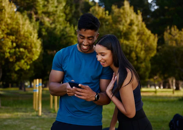 Young Multiracial Couple Wearing Sportswear Smiling While Using Mobile Phone — Stock Photo, Image