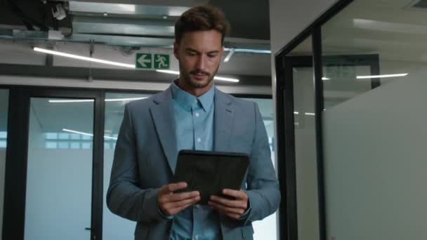 Şirketin Koridorunda Yürürken Dijital Tablet Kullanan Kafkasyalı Genç Adam — Stok video