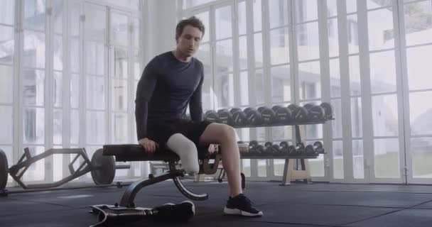 Young Caucasian Man Taking Break Putting Prosthetic Leg Next Weights — Stock Video