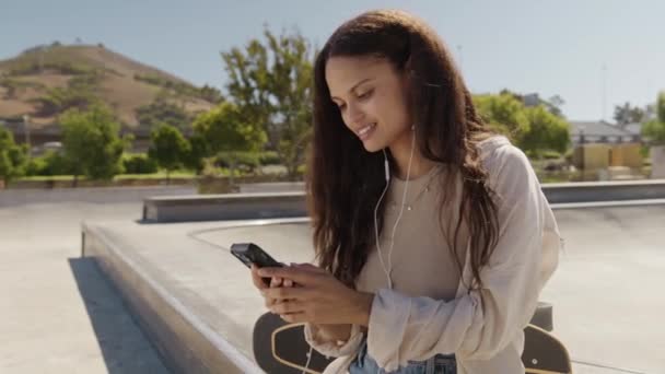 Молодая Многонациональная Женщина Повседневной Одежде Смеется Пользуясь Мобильным Телефоном Скейтпарке — стоковое видео