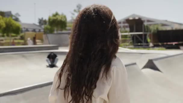 Glad Ung Flerrasekvinne Iført Uformelle Klær Som Smiler Skateparken – stockvideo