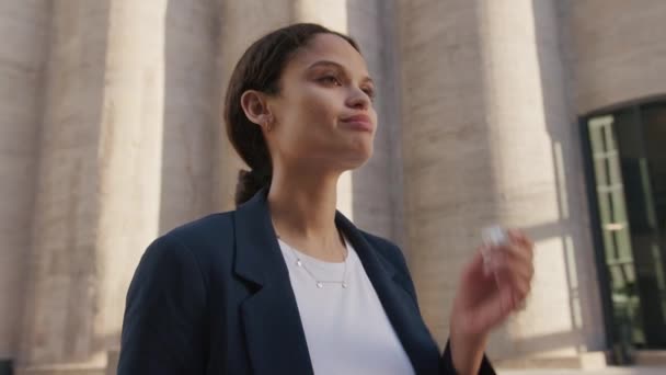 Young Multiracial Woman Wearing Businesswear Using Wireless Headphones Next Building — Stock Video