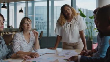 İş hayatında bir grup çok ırklı insan ofiste toplantı yaparken tartışıyorlar.