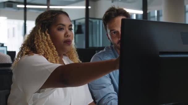 企業のオフィスでコンピュータを使用している間 ジェスチャーする若者と大人の女性 — ストック動画