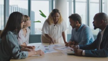 Bir grup çok ırklı iş arkadaşı ofiste toplantı sırasında tartışıyorlar.