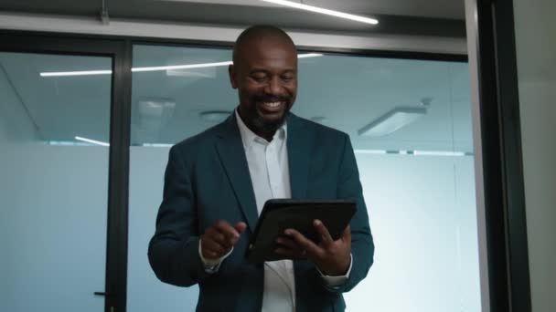 Şirketin Koridorunda Yürürken Dijital Tablet Kullanan Mutlu Olgun Siyahi Bir — Stok video
