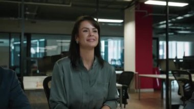 Şirketin ofisinde iş kıyafetleri içinde el sıkışan dört mutlu çok ırklı iş arkadaşı.