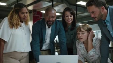 Bir grup mutlu çok ırklı iş adamı toplantı sırasında toplantı odasında dizüstü bilgisayarın önünde konuşuyorlar.