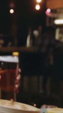 Çok ırklı bir arkadaş grubu bir restoranda bira bardaklarını tokuşturuyor. Yüksek kalite 4k görüntü
