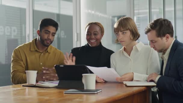 企業オフィスでのミーティング中にデジタルタブレットを使用してビデオ通話をするビジネスウェアを着用している4人の若者 — ストック動画