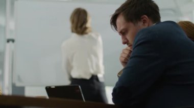 Şirket ofisindeki toplantı sırasında dört çok ırklı iş adamı beyaz tahtaya yazı yazıp konuşuyor.