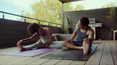 Bir çift, adamın liderliğindeki ahşap bir balkonda yoga seansının tadını çıkarıyor. Şınav çekerek ve bacak esnetmeyle başlarlar. Huzurlu ortam, dingin atmosfere katkı sağlar.