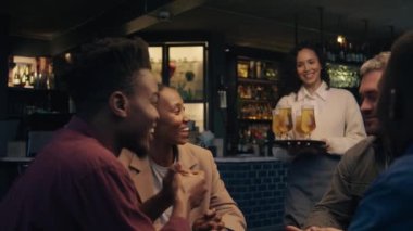 Modern bir restoranda müşterilere içkilerini teslim eden beyaz bir garson. Yüksek kalite 4k görüntü
