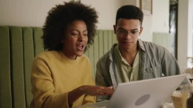 Karışık ırk adamı, modern bir kahve dükkanındaki Afrikalı Amerikalı iş arkadaşına işi anlatıyor. Yüksek kalite 4k görüntü