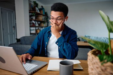 African American man nervous about his assignment in a modern apartment. High quality photo clipart