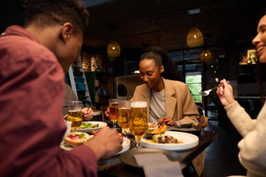 Modern bir restoranda yemek yiyen bir grup arkadaş. Yüksek kalite fotoğraf