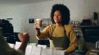 Modern bir kahve dükkanında bir müşteriye kahve veren Afrikalı Amerikalı barista. Yüksek kalite 4k görüntü