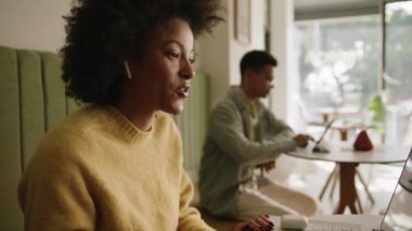 Modern bir kahve dükkanında iş görüşmesi yapan Afro-Amerikalı bir kadın. Yüksek kalite 4k görüntü