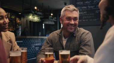 Bir grup meslektaşım işten sonra modern bir restoranda bira içiyorlar. Yüksek kalite 4k görüntü