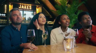 Modern bir restoranda futbol maçı izleyen bir beyaz ve siyah bir çift. Yüksek kalite 4k görüntü