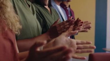 Çok kültürlü iş adamları alkışlıyor ve gülümsüyor modern ofiste.