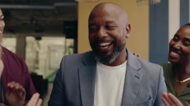 Çeşitli iş arkadaşları, modern ofiste gündüz vakti olgun iş adamlarını alkışlıyor.