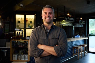 Modern bir restoranda kollarını kavuşturmuş beyaz bir adam. Yüksek kalite fotoğraf