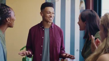 Gündüz vakti modern ofis alanında iş adamını alkışlayan bir grup farklı iş arkadaşı