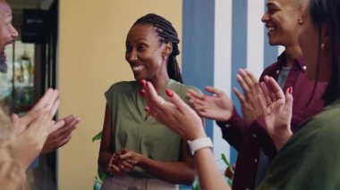 Gündüz vakti çeşitli iş arkadaşları, siyahi iş kadınlarını alkışlıyor.