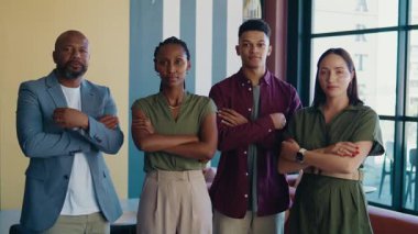 Bir grup ciddi iş adamı, modern ofiste kesişen şık gündelik giysiler içinde.