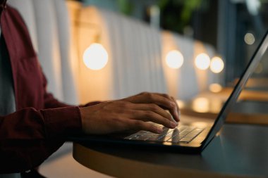 Aydınlatılmış modern ofisin masasında dizüstü bilgisayarda daktilo yazan işadamlarına yakın çekim