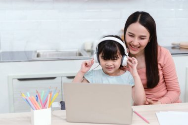 Asyalı anneler ve kızlar internet üzerinden bilgisayar kullanarak ve kulaklıkla sesi dinleyerek internetten öğreniyorlar.