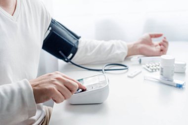 Sphygmomanometre Asyalı erkekler tarafından kullanılır, ölçüm araçları, tıbbi ve evde sağlık konsepti.