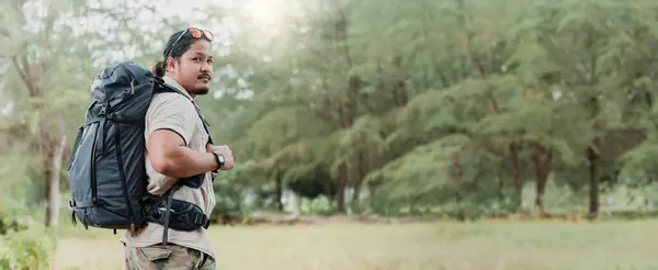 An adventurous soul embarks on a journey of self-discovery in the heart of nature. With a backpack as his companion, he treks through the tranquil woods, finding peace and relaxation amidst the lush greenery. This image captures the essence of outdoo