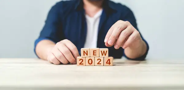 the essence of a fresh start in 2024. It features wooden blocks arranged to spell 2024 START, symbolizing the anticipation and planning for new goals in the upcoming year.