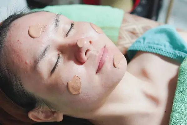 a woman indulging in a self-care ritual with a facial mask. She appears relaxed, embodying the shift from self-care as a luxury to a fundamental part of health and wellbeing.