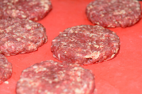 hamburger minced meatloaf gourmet meat blend isolated on red background with blurs
