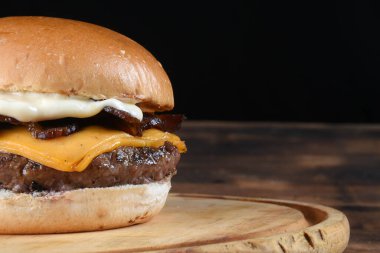 Hamburgerli biftek salata soğan ve peynirli fast food ahşap masaya izole edilmiş.