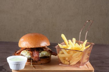 Lezzetli sığır burger, sandviç, salata, soğan ve peynirli fast food. Tahta masa yemeğinden izole edilmiş.